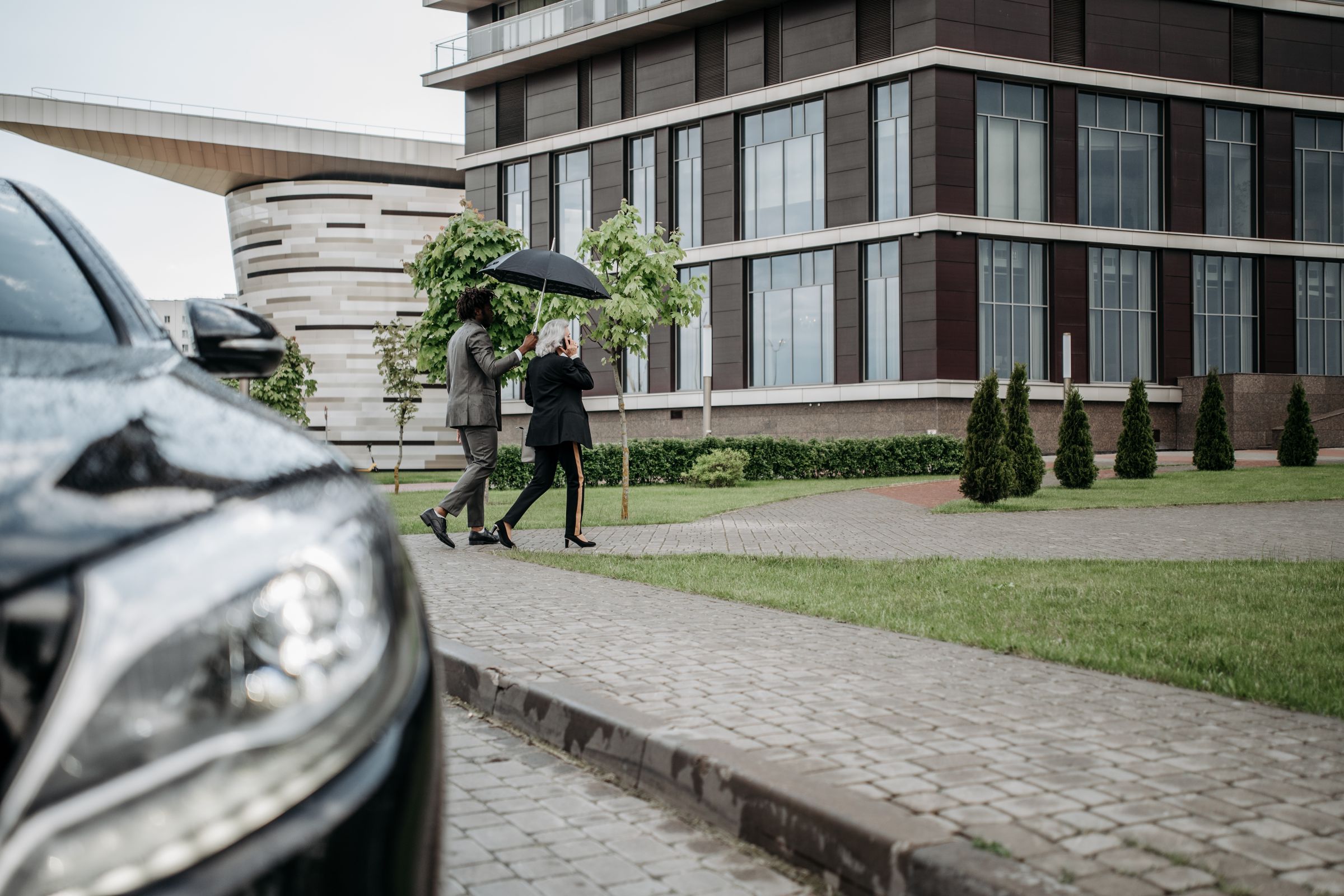 Close-protection professional accompanying a client from a secure vehicle