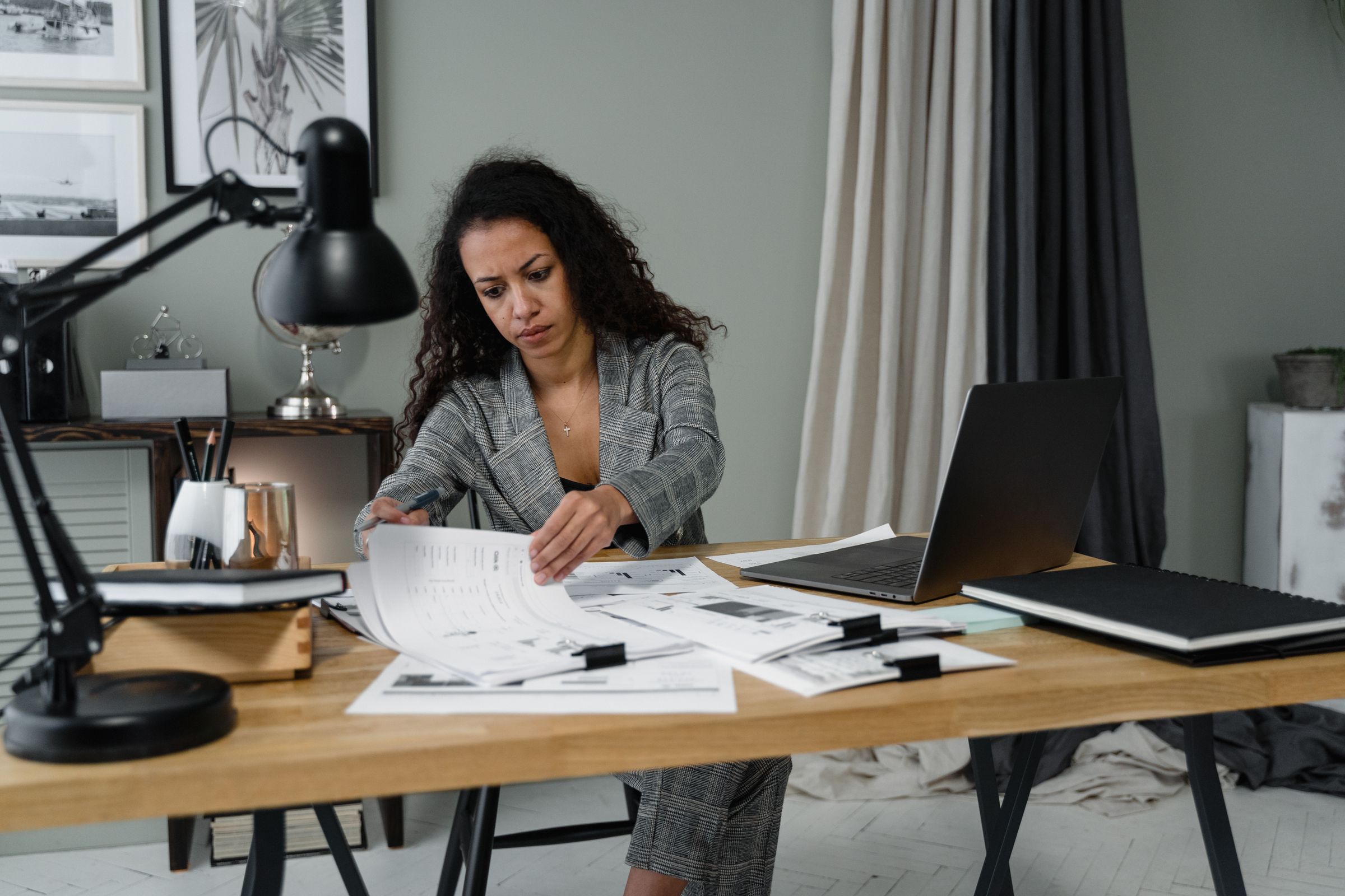 Professional auditor reviewing reports and working papers at an office desk